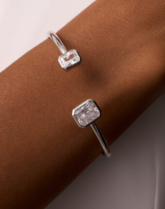 Серебряный жесткий браслет с ассиметричными фианитами в огранке Эмеральд MIE женщинам